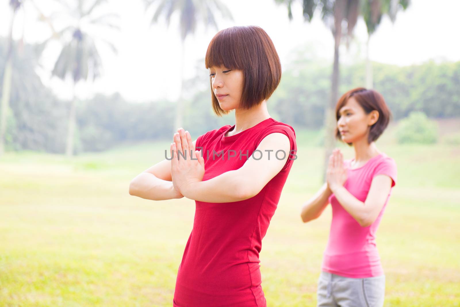 Asian girls performing yoga at outdoor park