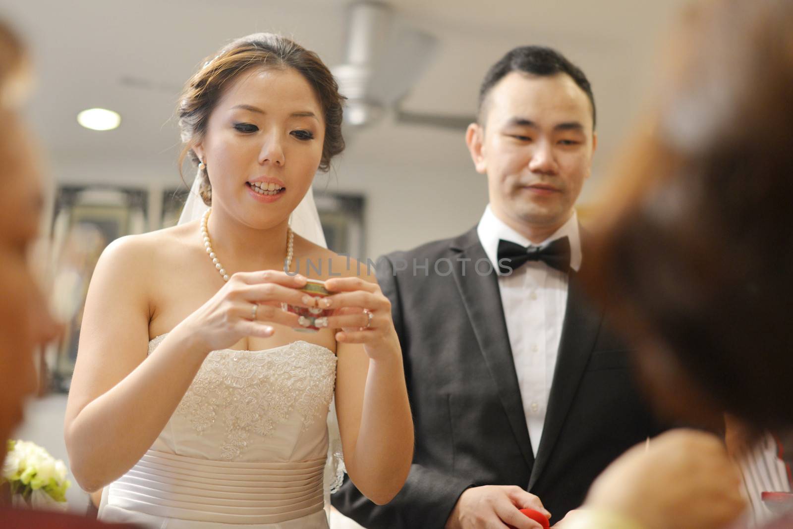 Traditional Chinese wedding, bride and groom serving tea to elders.