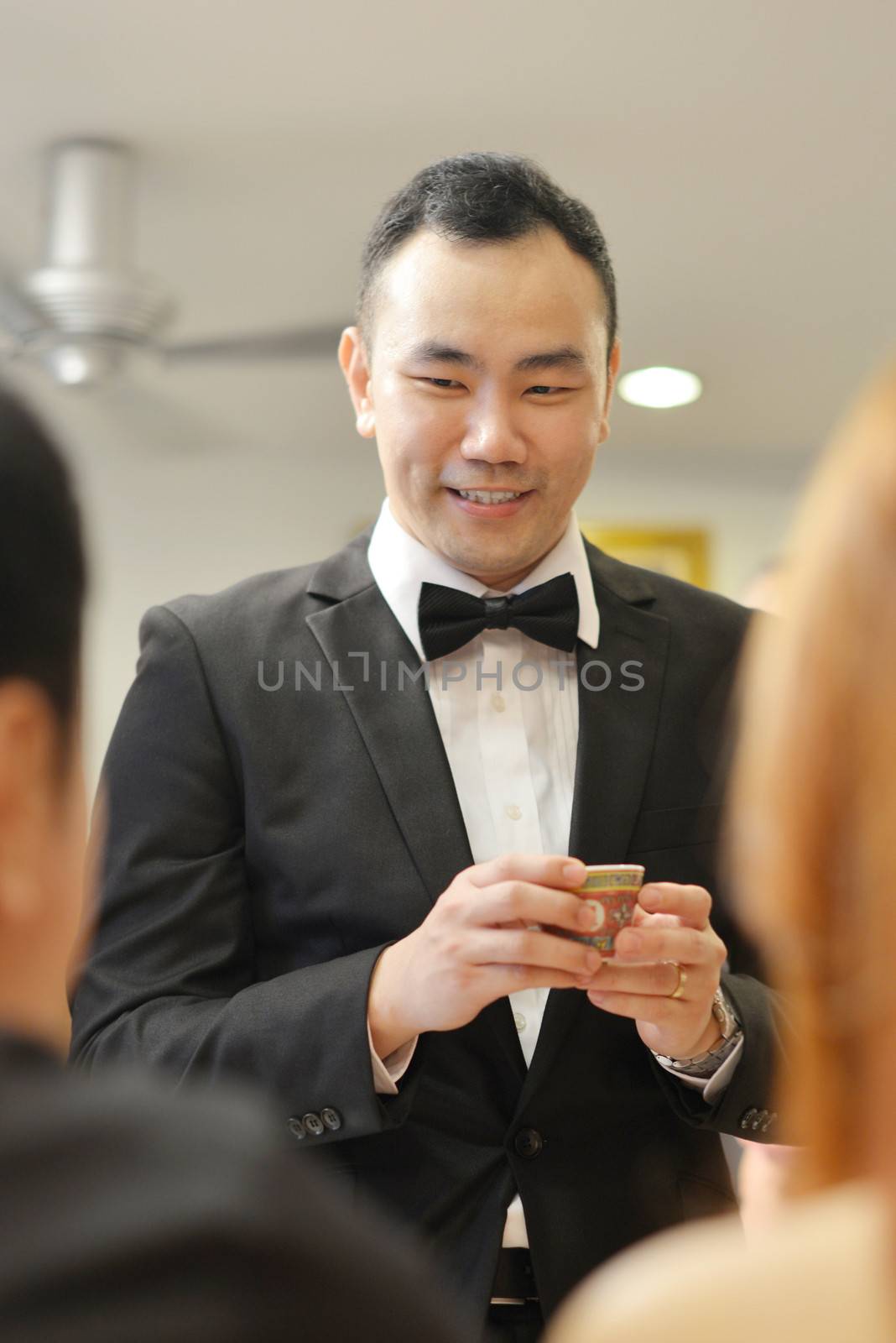Traditional Chinese wedding, groom serving tea to elders.