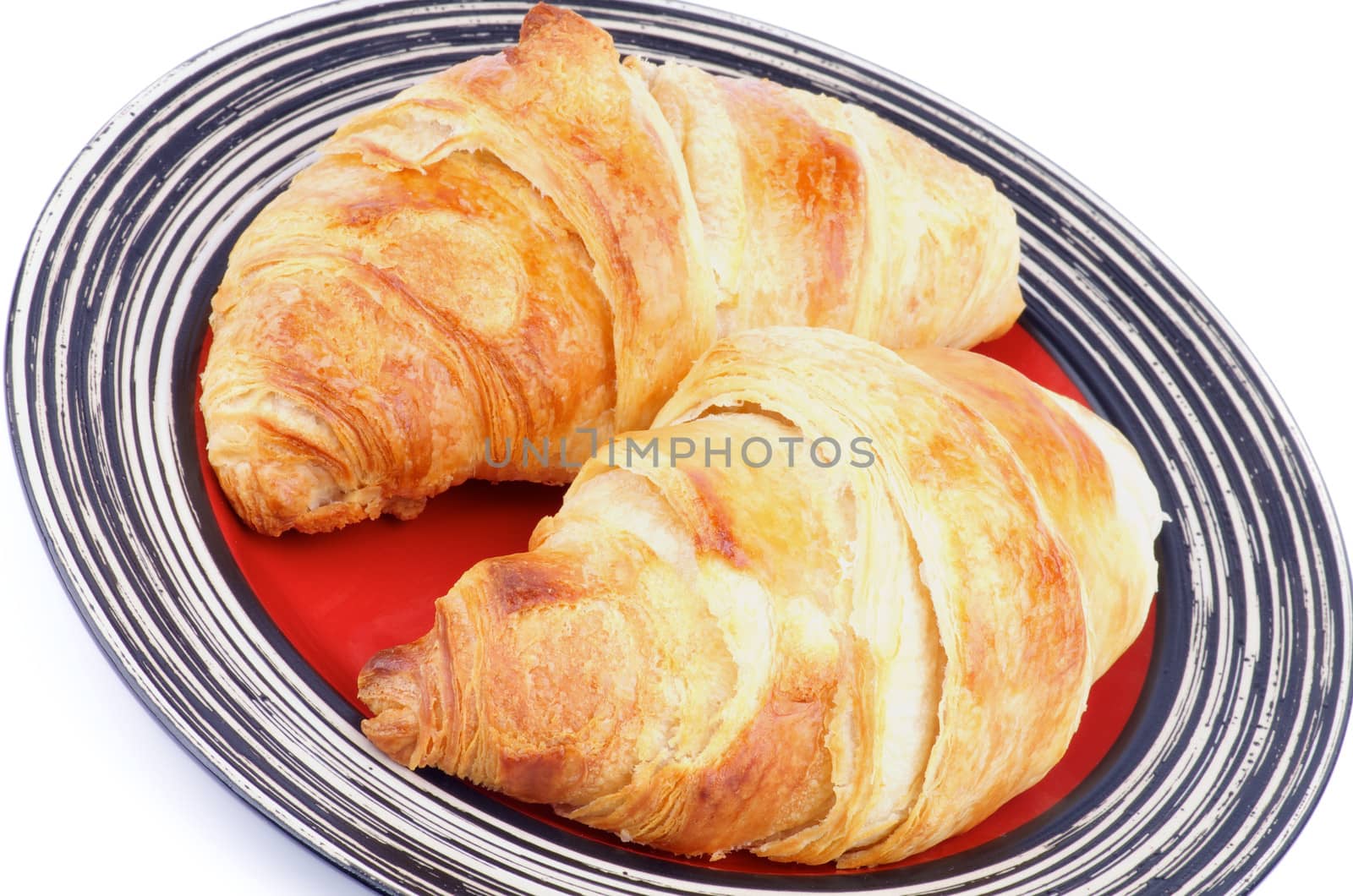 Two Freshly Baked Croissants on Red Striped Plate closeup on white background