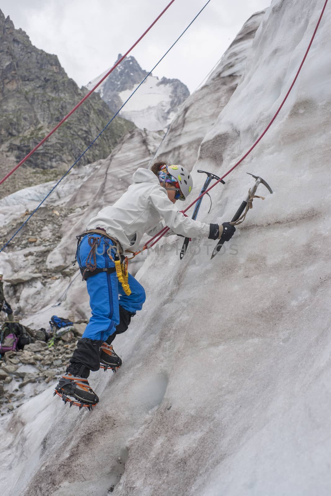 Girl climb up on the ice at glacier