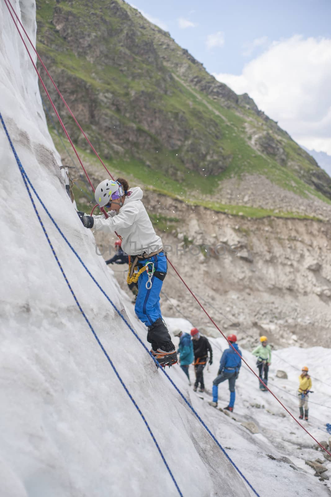 Girl climb up on the ice at glacier