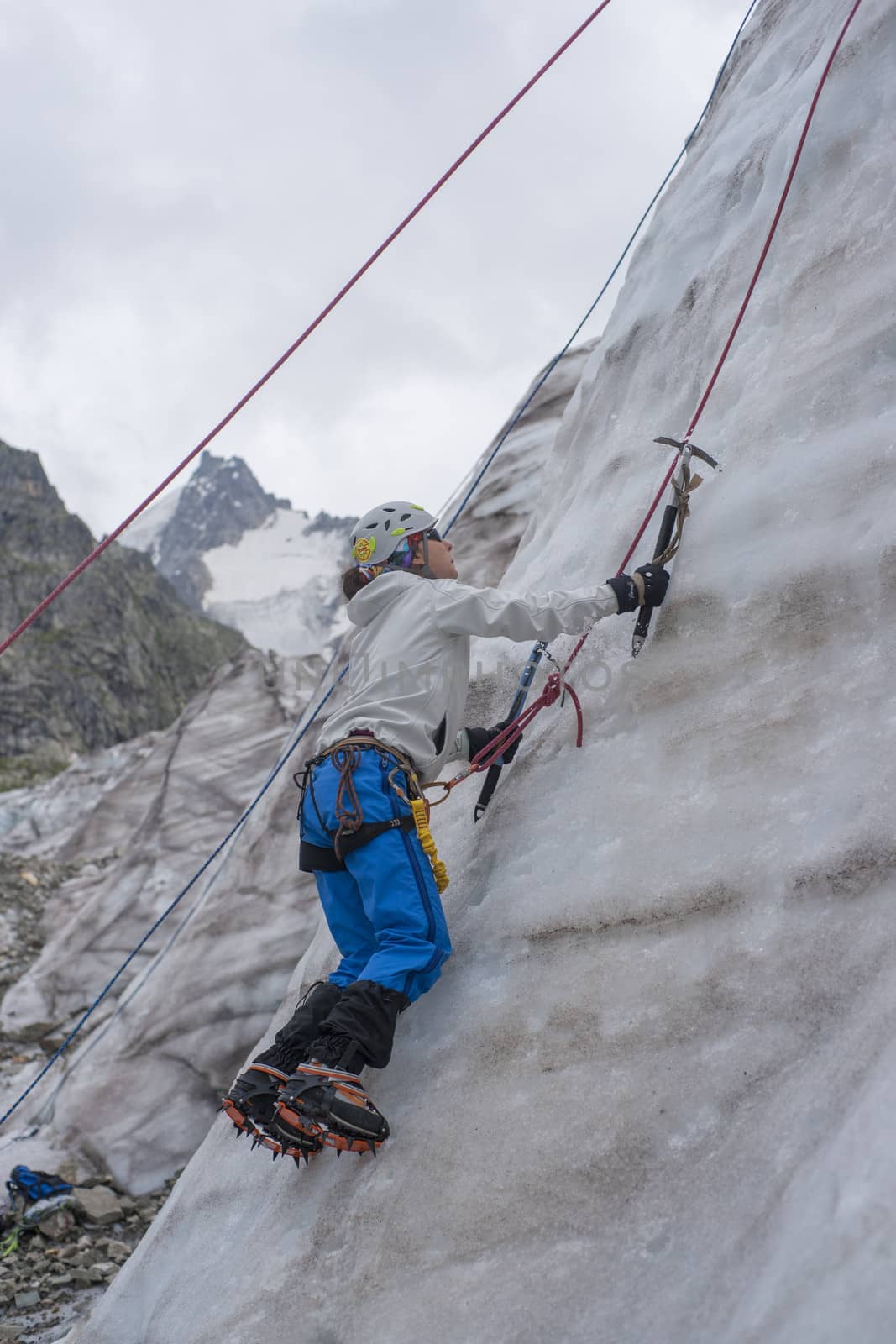 Girl climb up on the ice at glacier