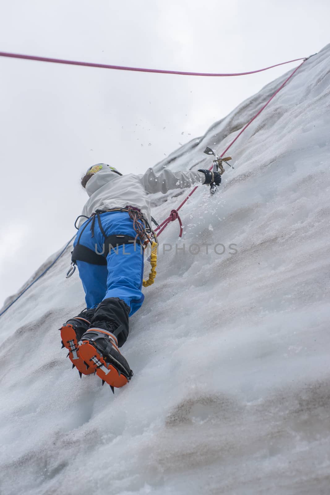 Girl climb up on the ice at glacier