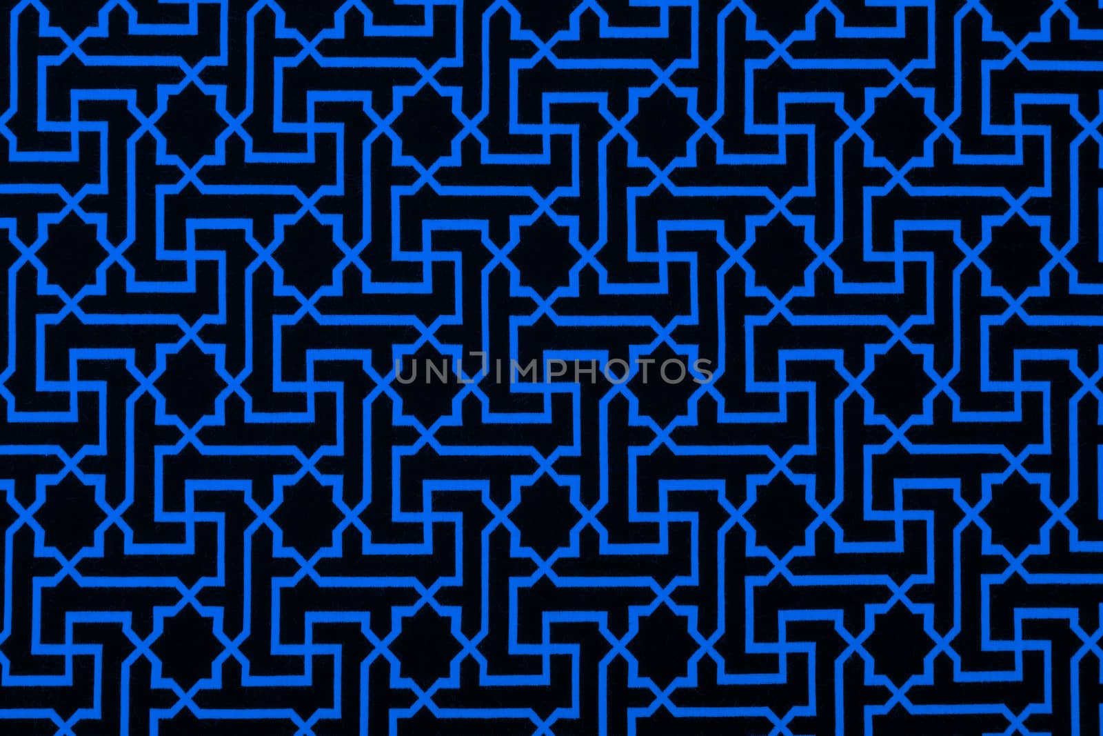 The material in geometric patterns, a blue textile background.