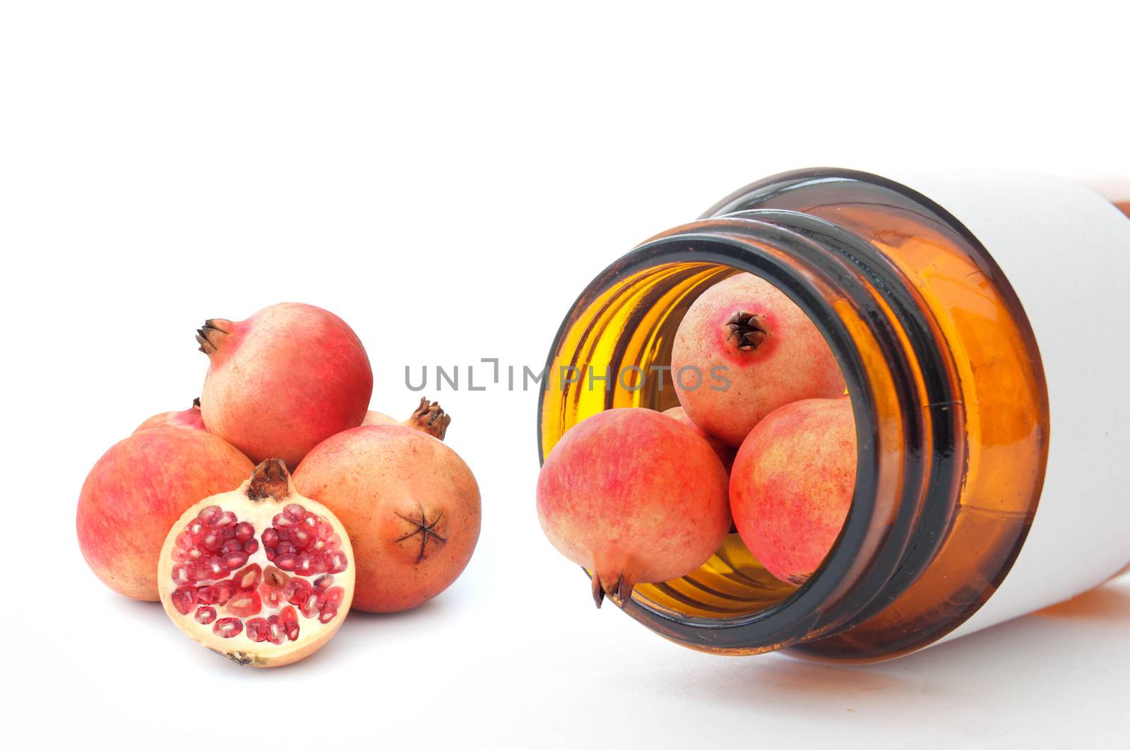 Miniature pomegranate fruits inside a vitamin pill container 