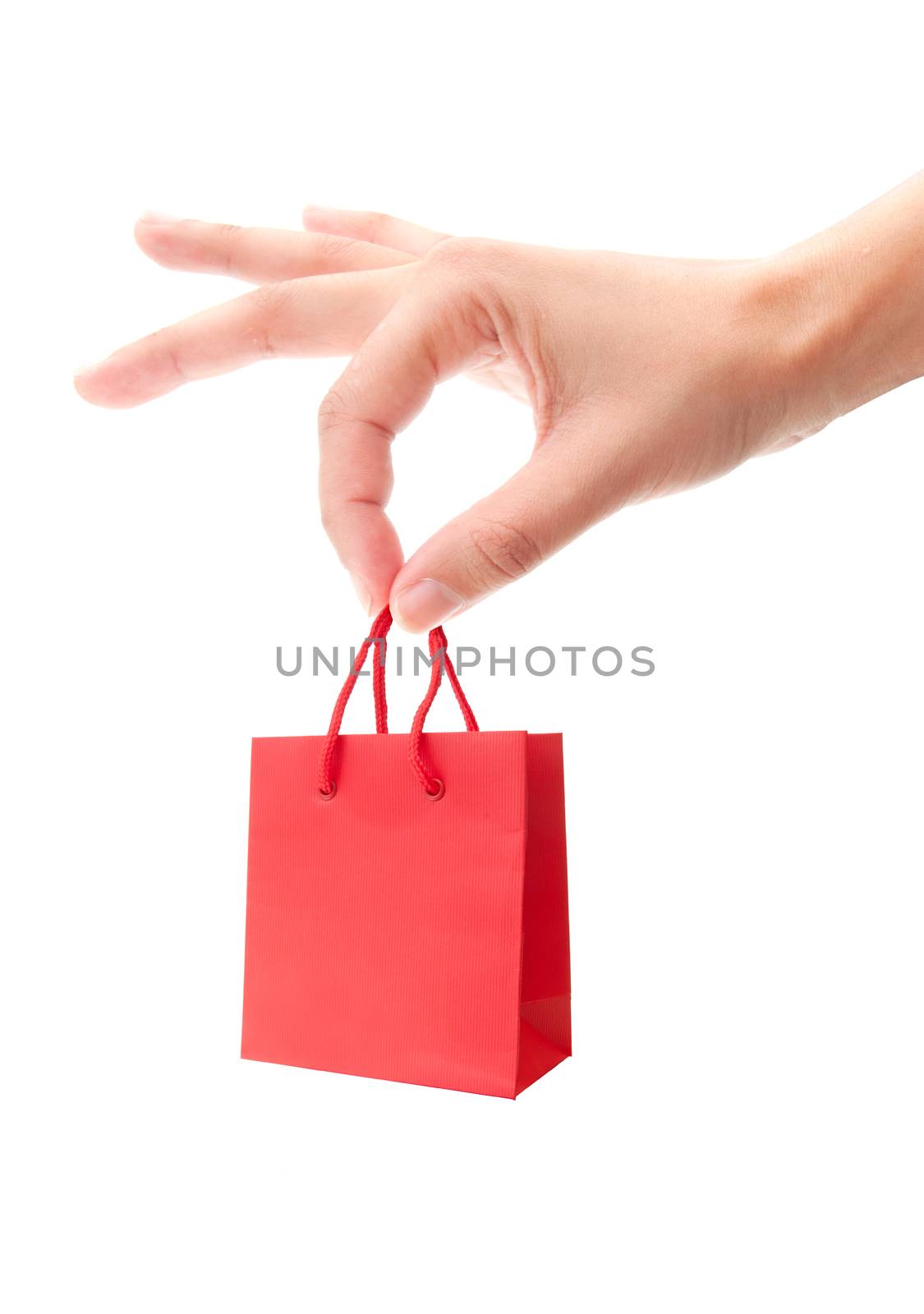 Hand holding a miniature red shopping bag over a white background