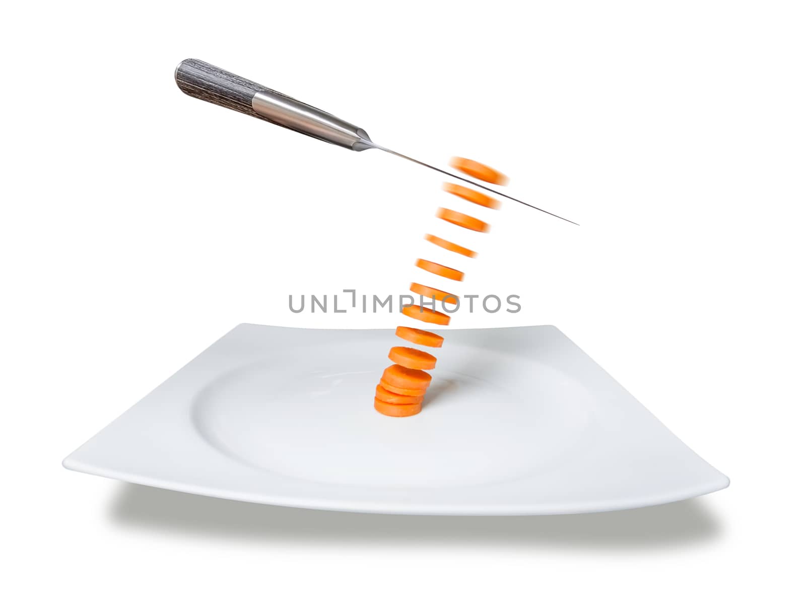 Knife slicing carrot in the air over plate isolated on white background