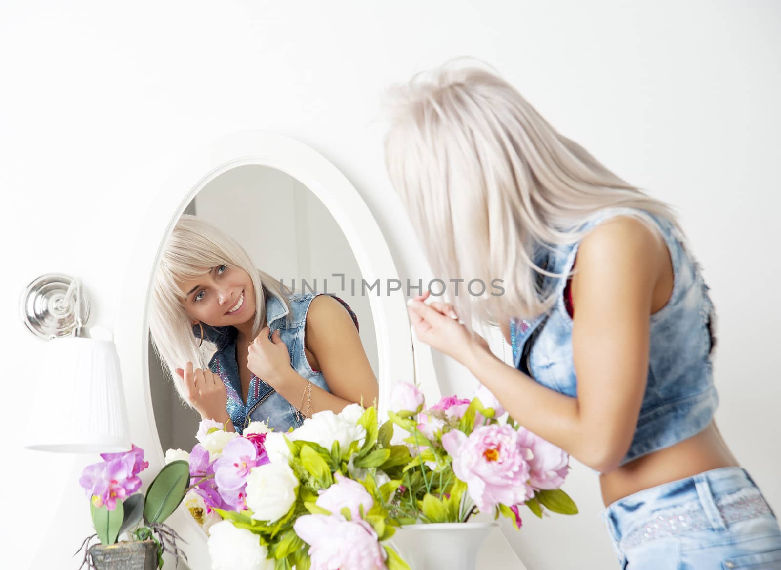 woman in front of the mirror over the dressing tables with flowers