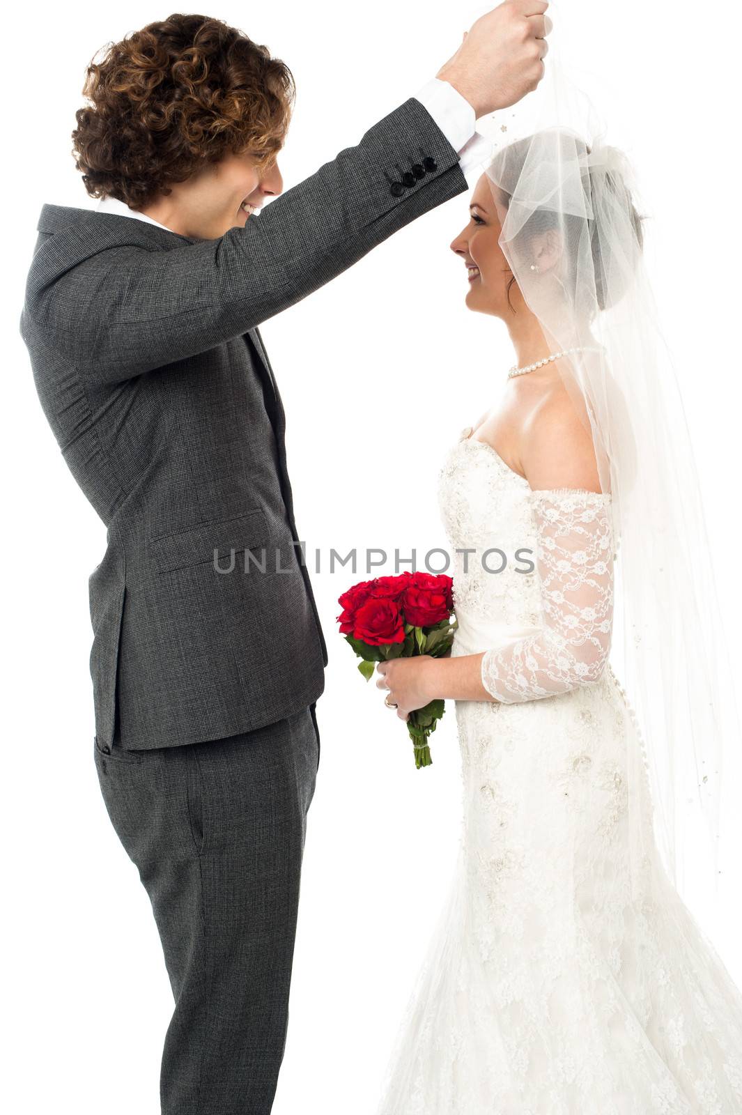 Young groom open the bridal's wreath and admiring each other