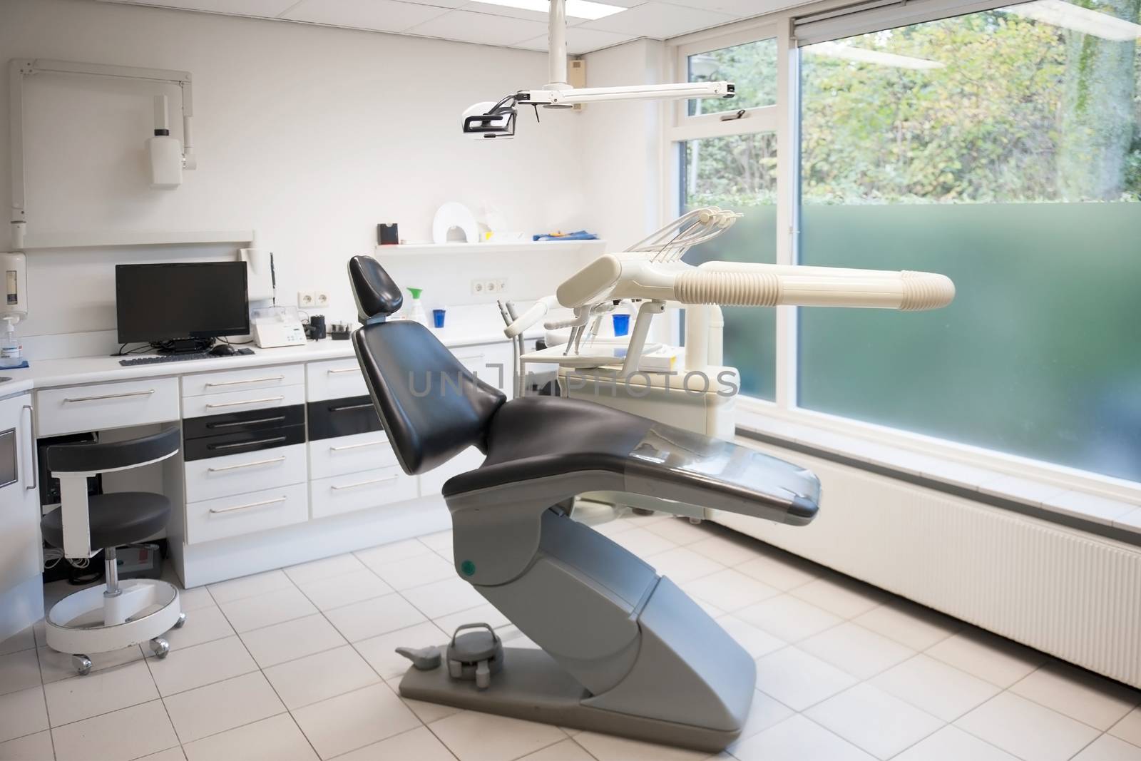 a consulting room in a dental practice, with a chair, instruments and a computer