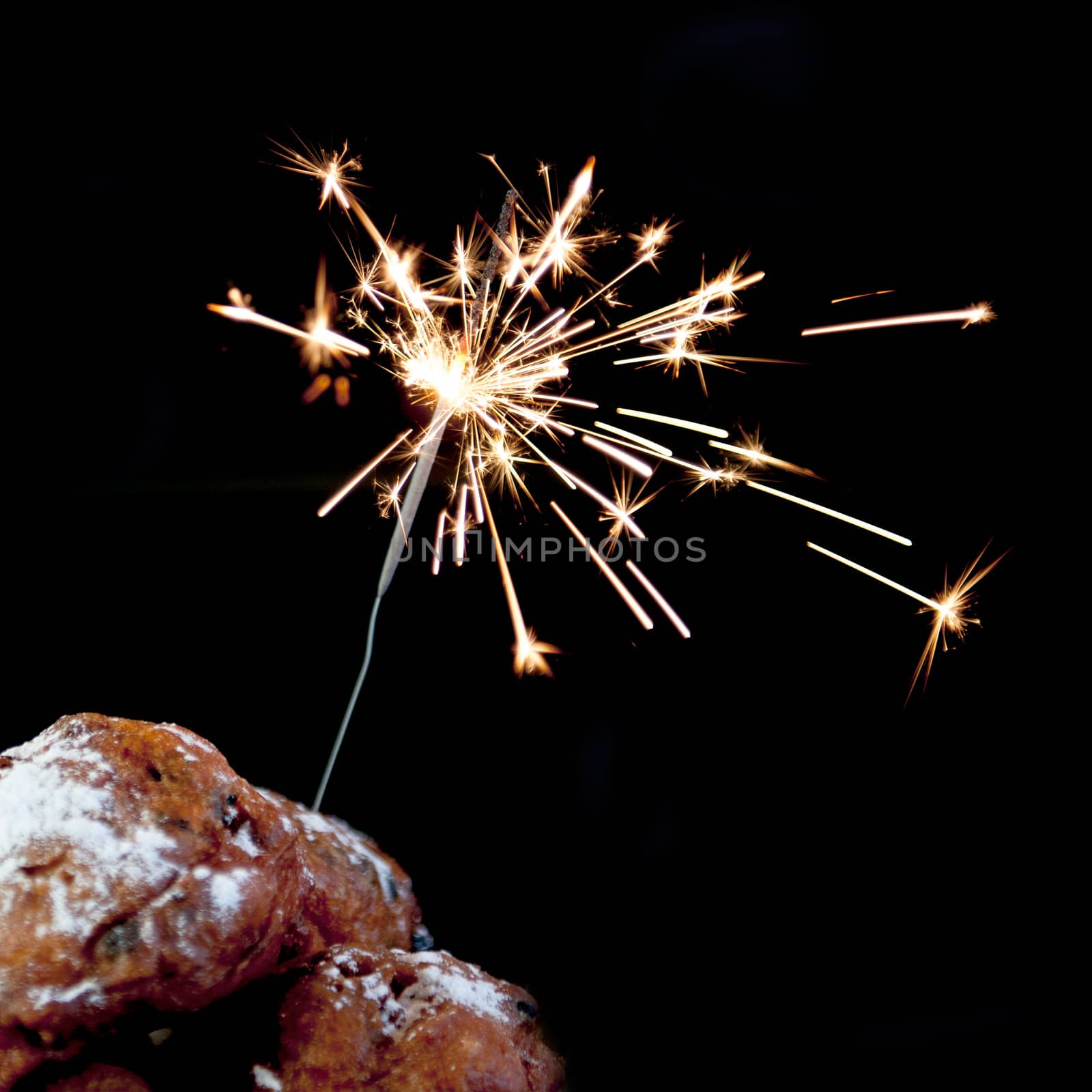 a pile with oliebollen with fireworks on a white background