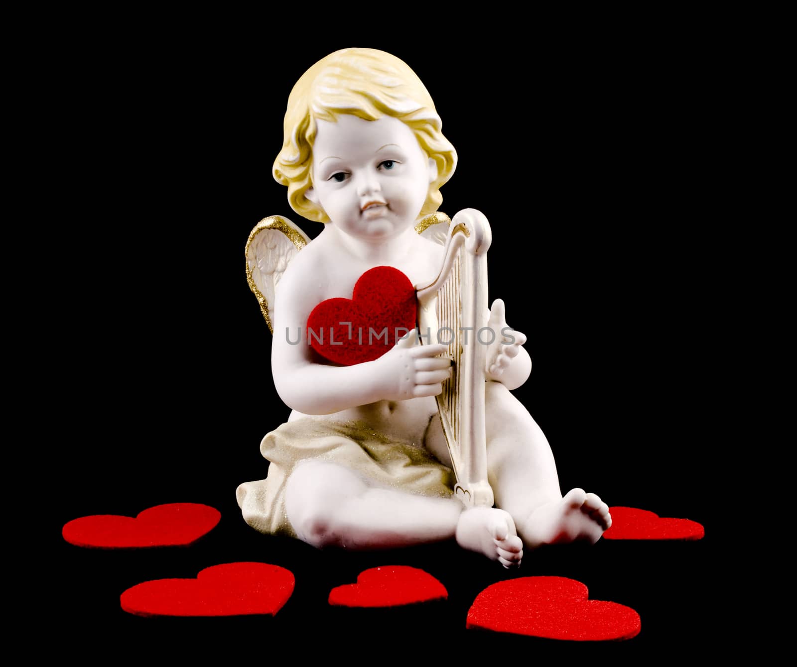 Ceramic cupid figure with felt red heart on black background