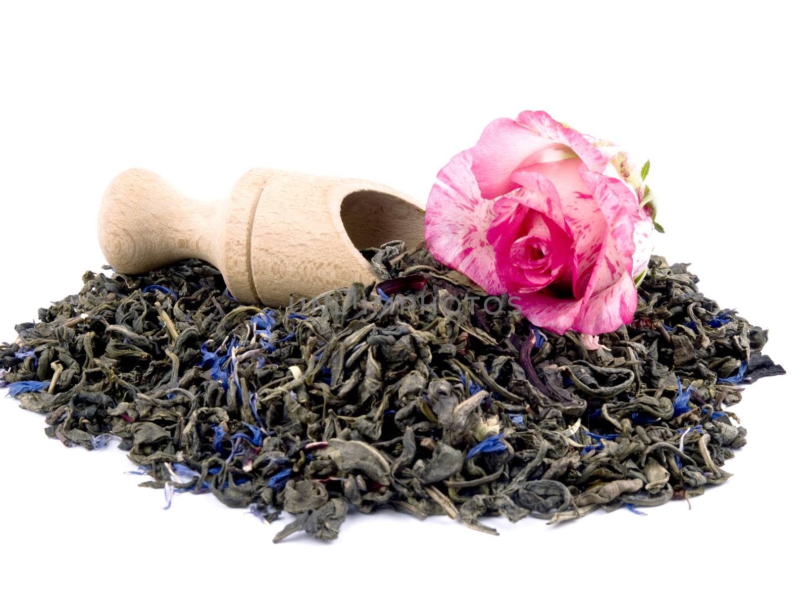 Aromatic green tea leaves with hibiscus and cornflower petals, wooden shovel on white background