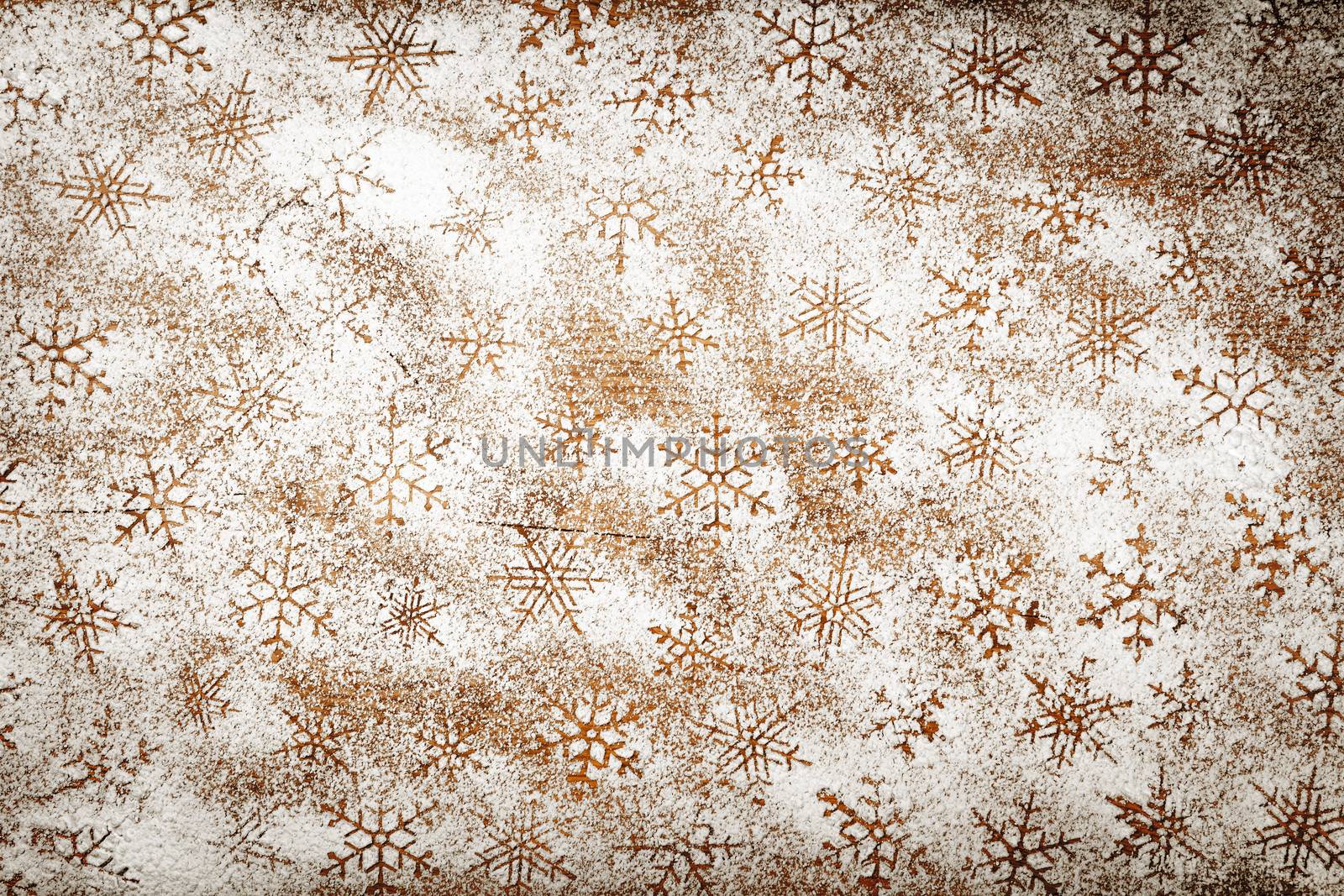 Winter background with snowflakes for Christmas. Snowflake pattern made of icing sugar on wooden table. Top view