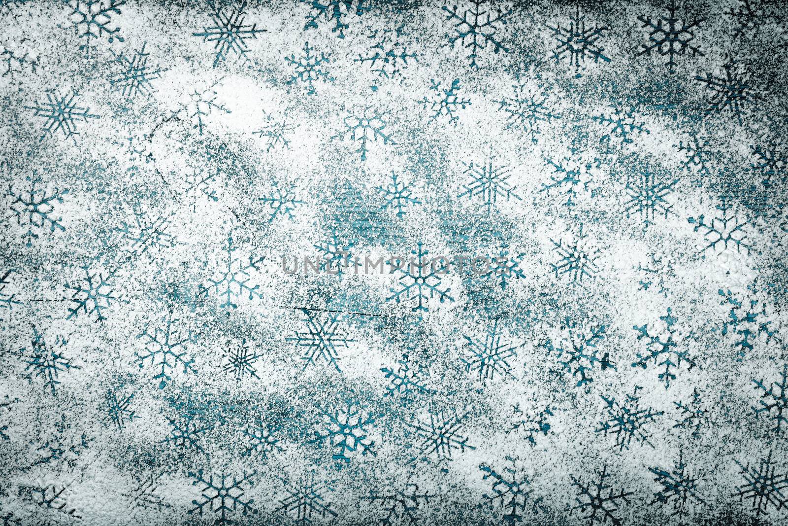 Snowflakes background for Christmas. Snowflake pattern made of icing sugar on wooden table. Top view