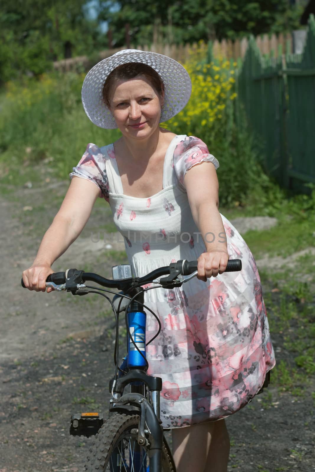 middle-aged woman in a hat on a bicycle
