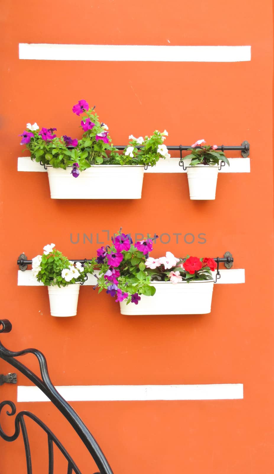 wall of the building with wrought holders and flowers in pots