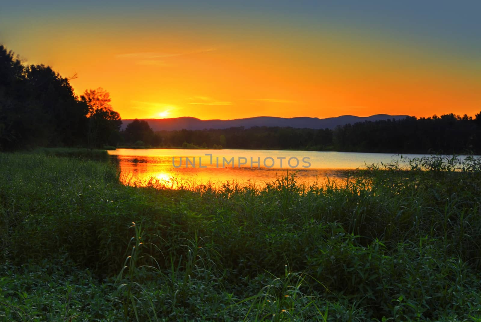 A view of the sun setting behind the famous Blue Mountains Australia, from lagoon at Agnes Banks.  Although a public reserve and recreation area, ithe 78 ha site is also a conservation zone and wildlife refuge