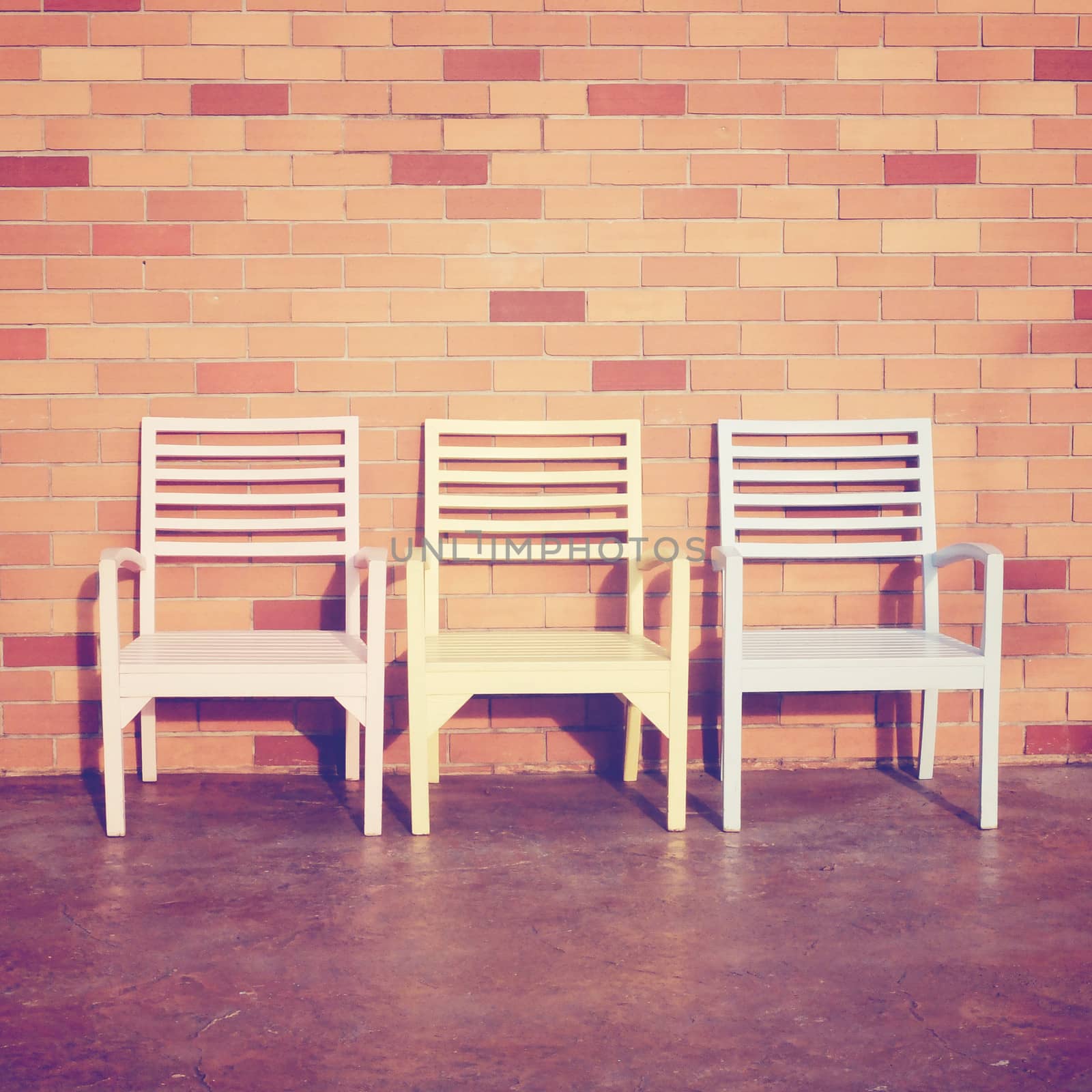 Three wooden chairs with brick wall, retro filter effect by nuchylee
