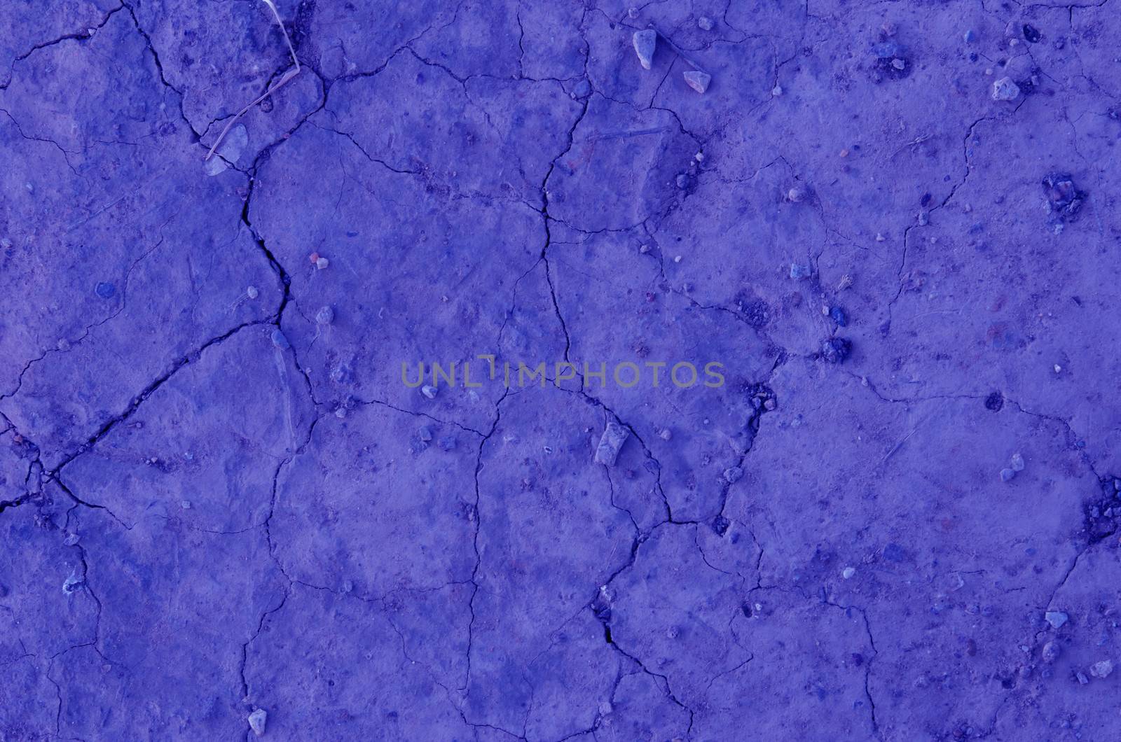 Close up dry land. Cracked ground blue color background.