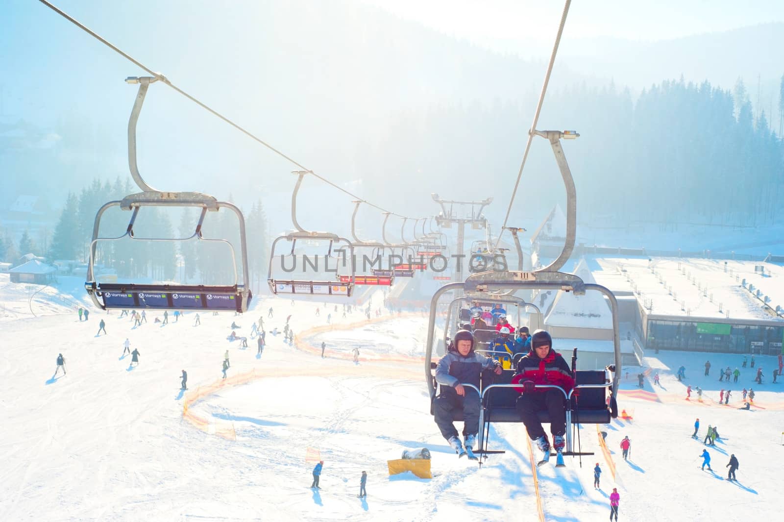 Bukovel, Ukraine - December 13, 2013: Skiers on a ski-lift  in Bukovel. Bukovel - is the largest ski resort in Ukraine. In 2012 it was named the most fast growing world ski resort.