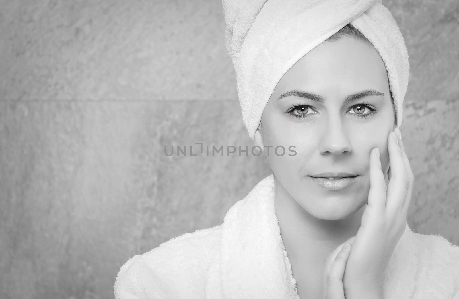 Portrait of beautiful young woman wearing a white bathrobe on the bathroom