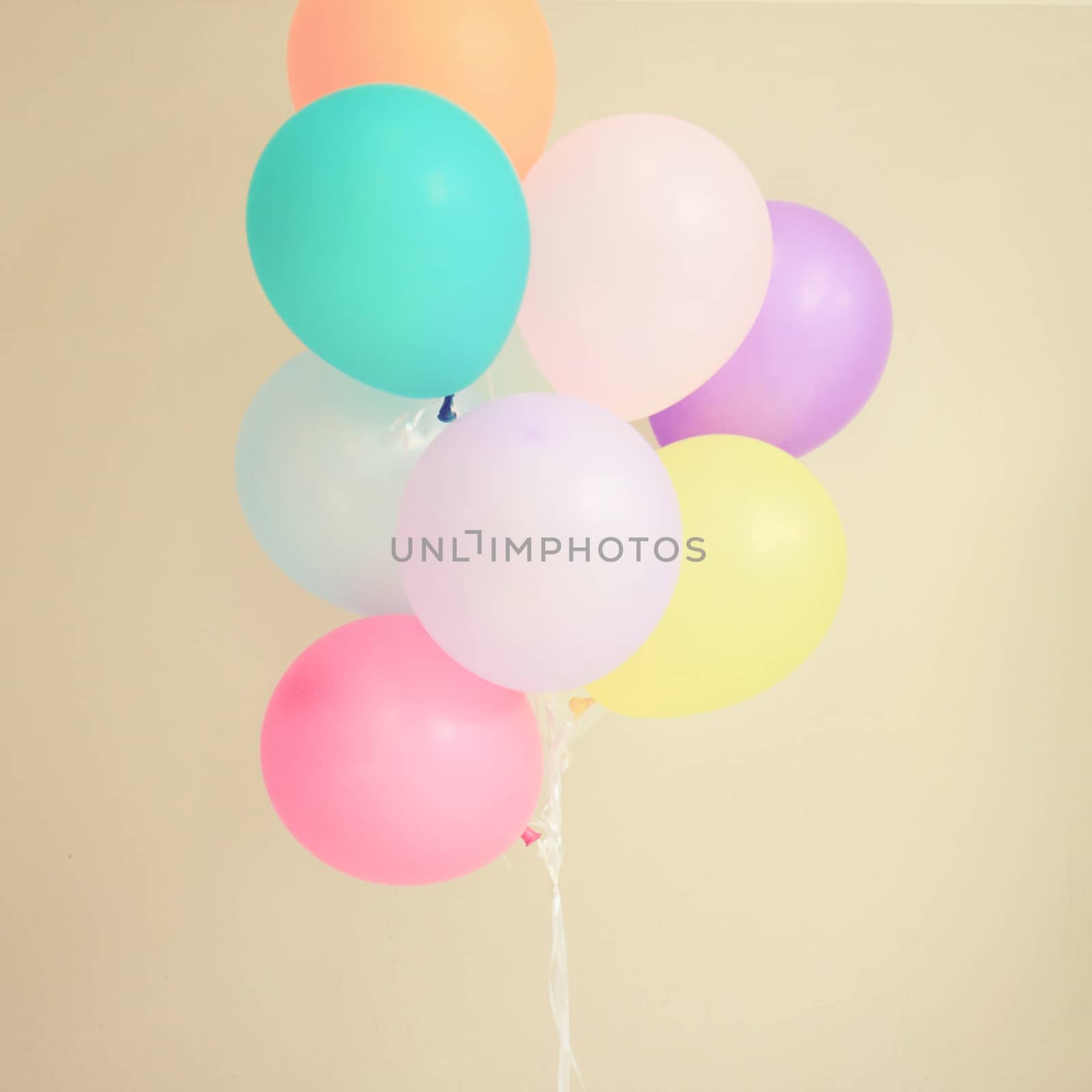 Colorful festive balloons on wall with retro filter effect  by nuchylee