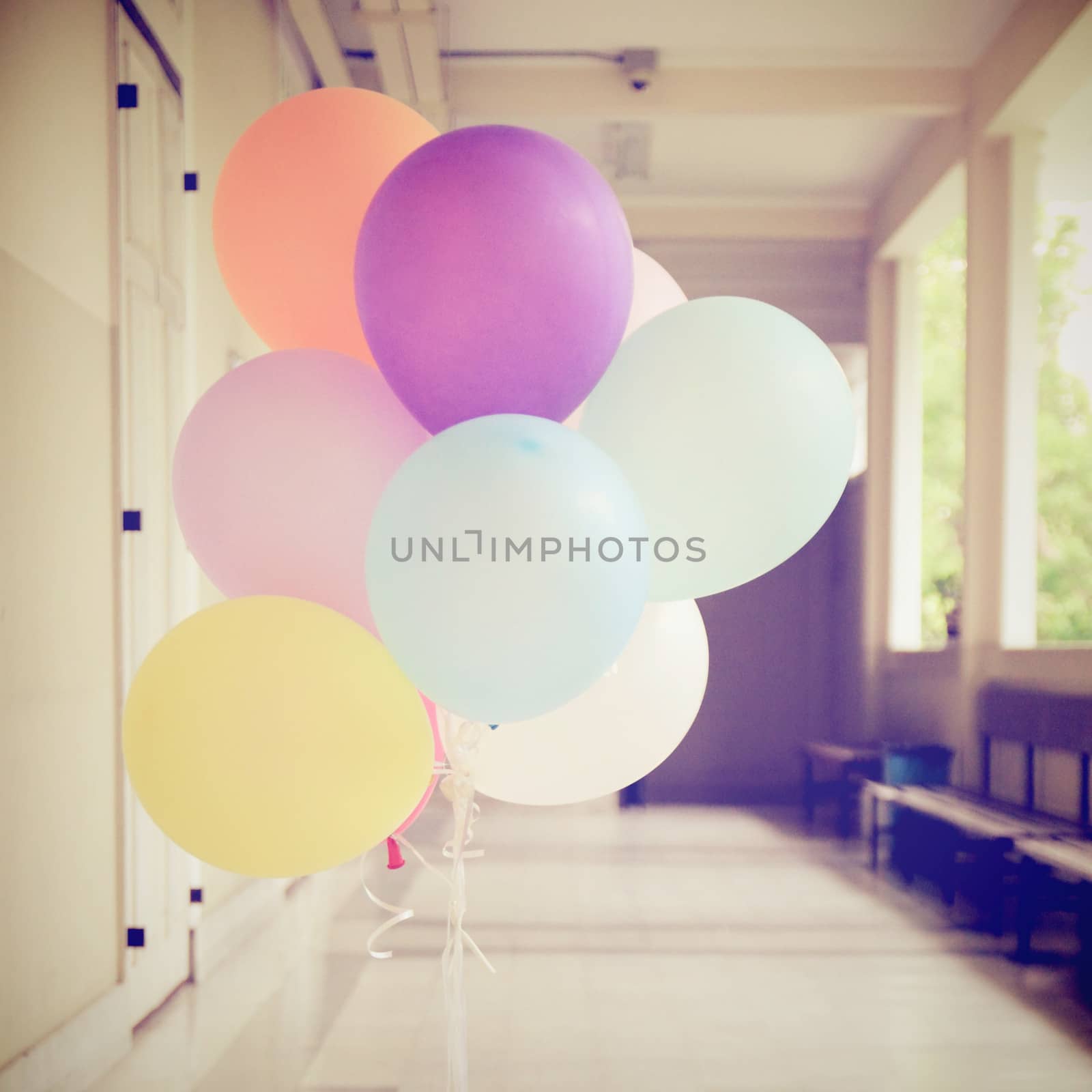 Colorful festive balloons decorated in hallway with retro filter by nuchylee