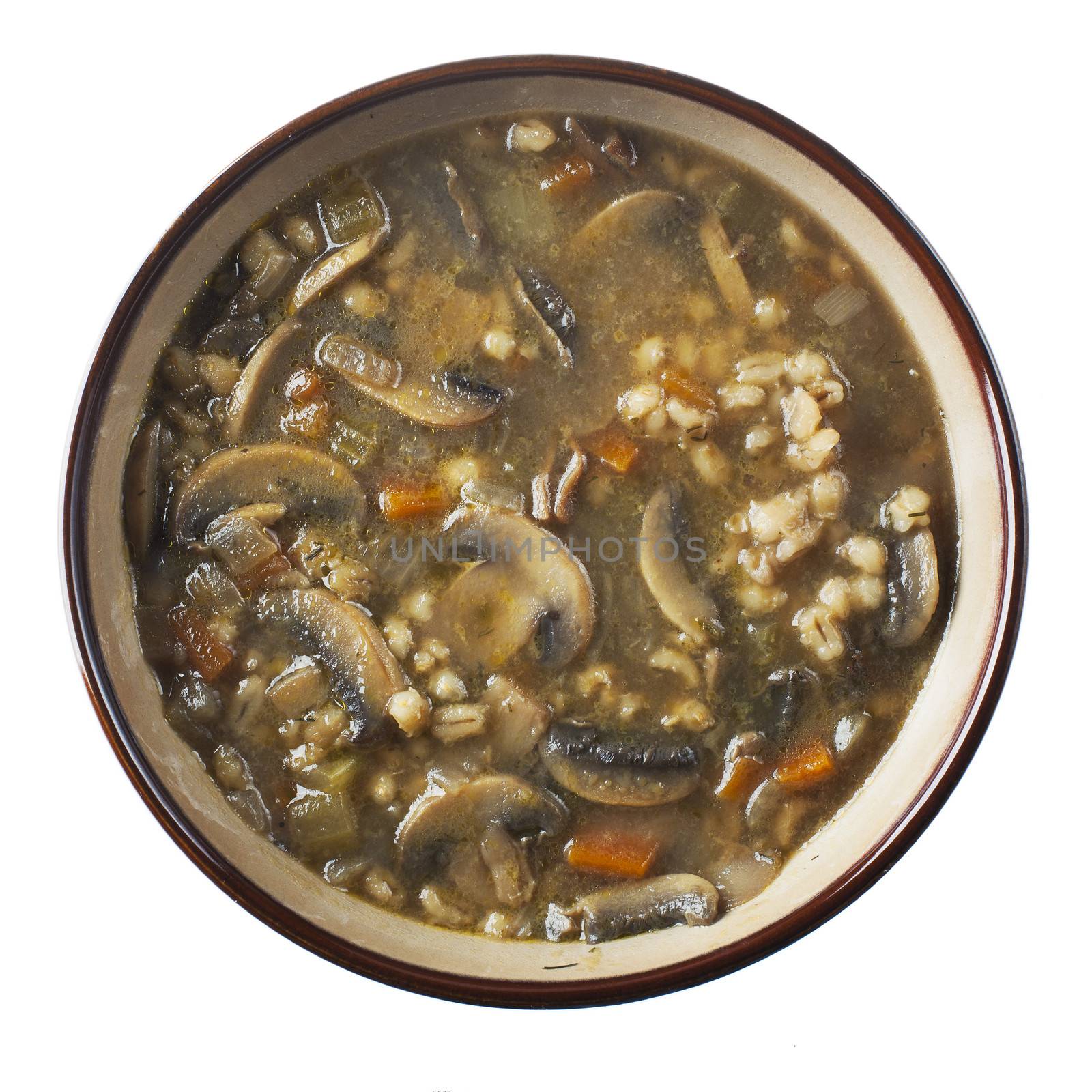 Bowl of homemade mushroom and barley sou isolated on white, from directly above.