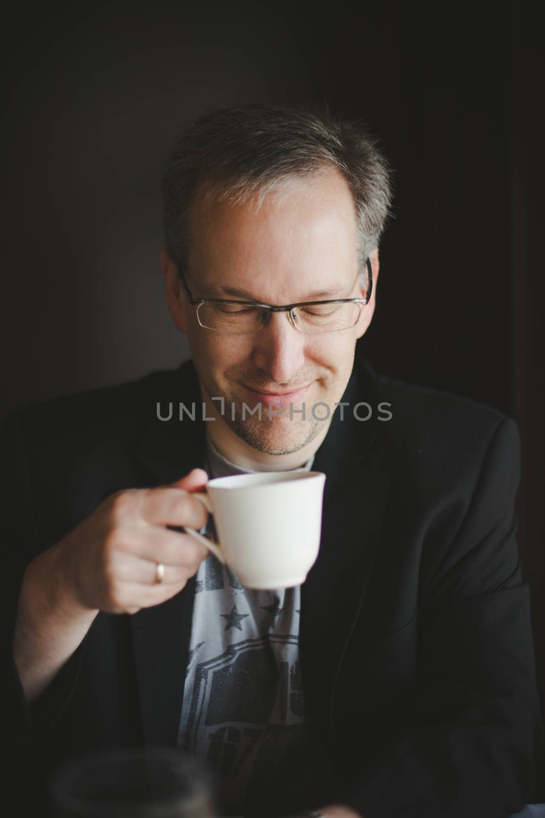 Man with a jacket having a coffee in a restaurant