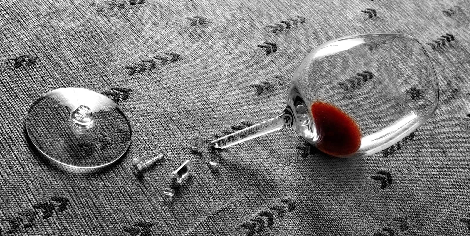 Red wine in broken glass half desaturated