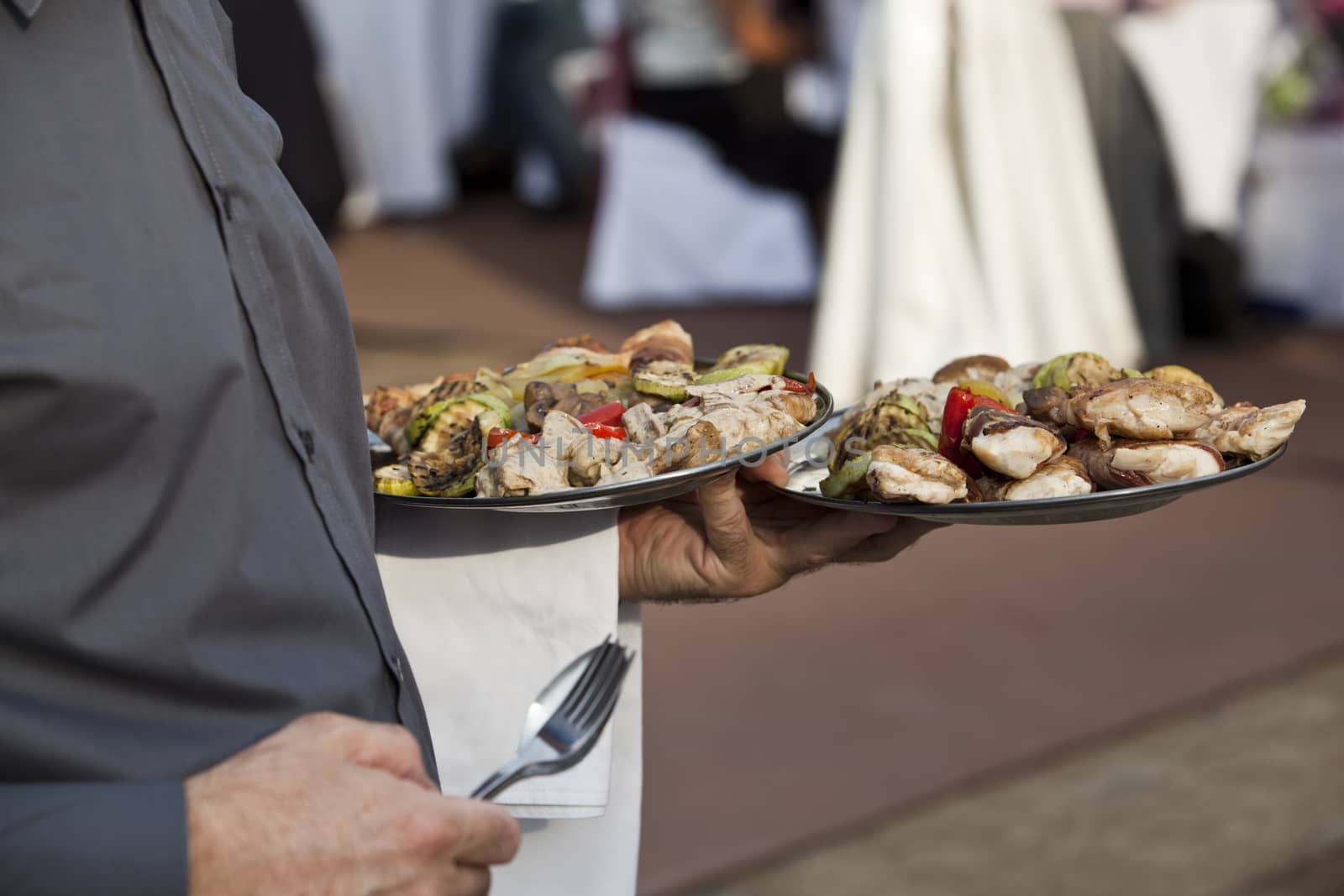 Waiter carrying plates of food