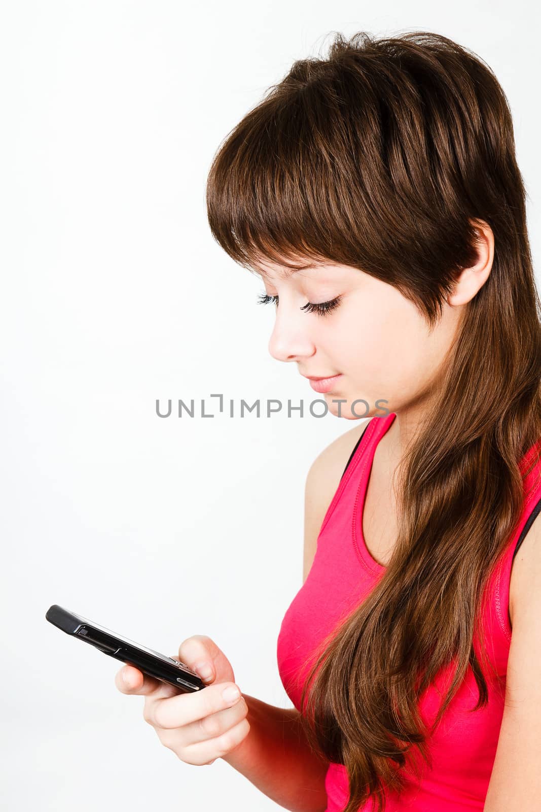 A young girl writes sms from mobile phone