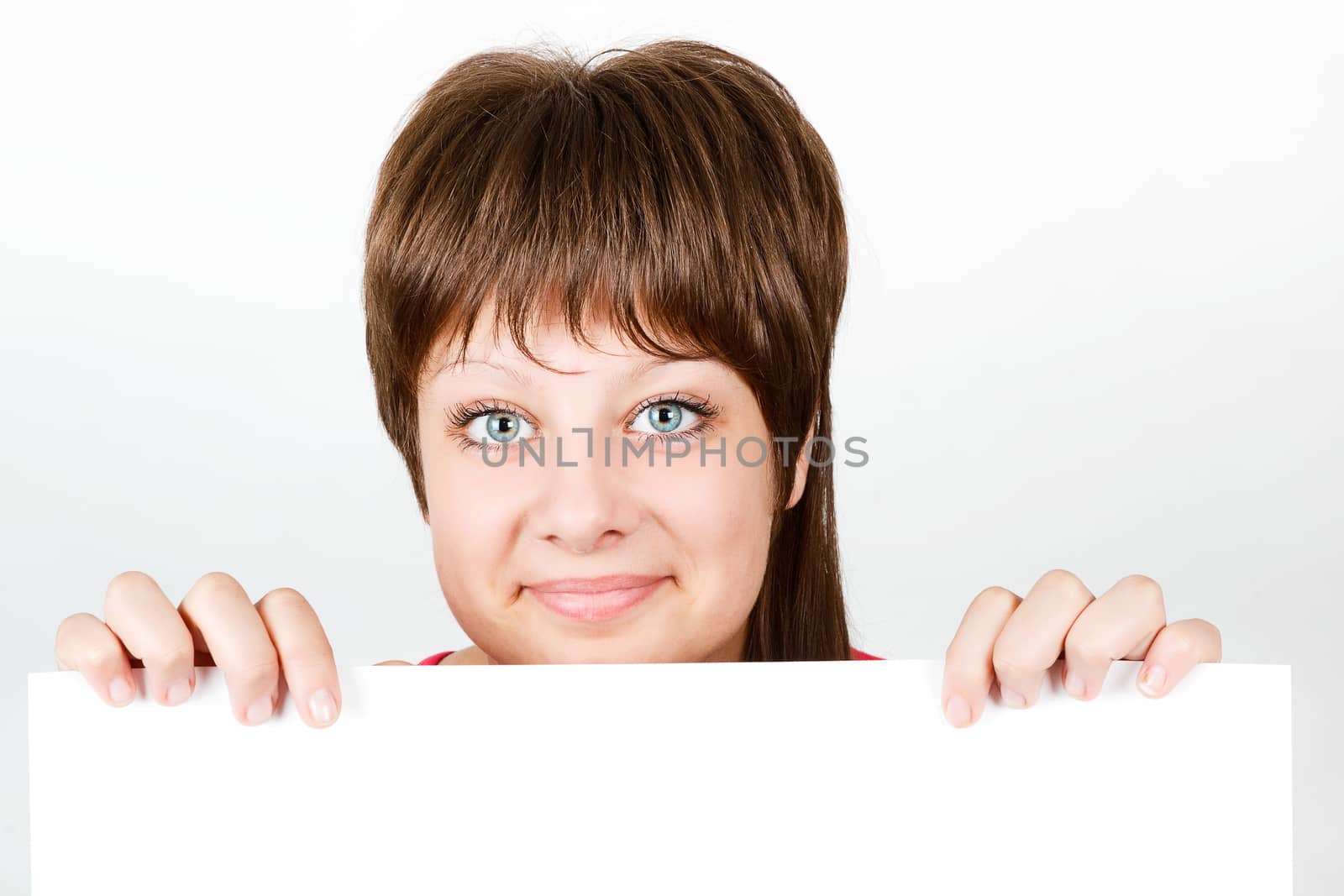 Young attractive girl looking from behind a white sheet