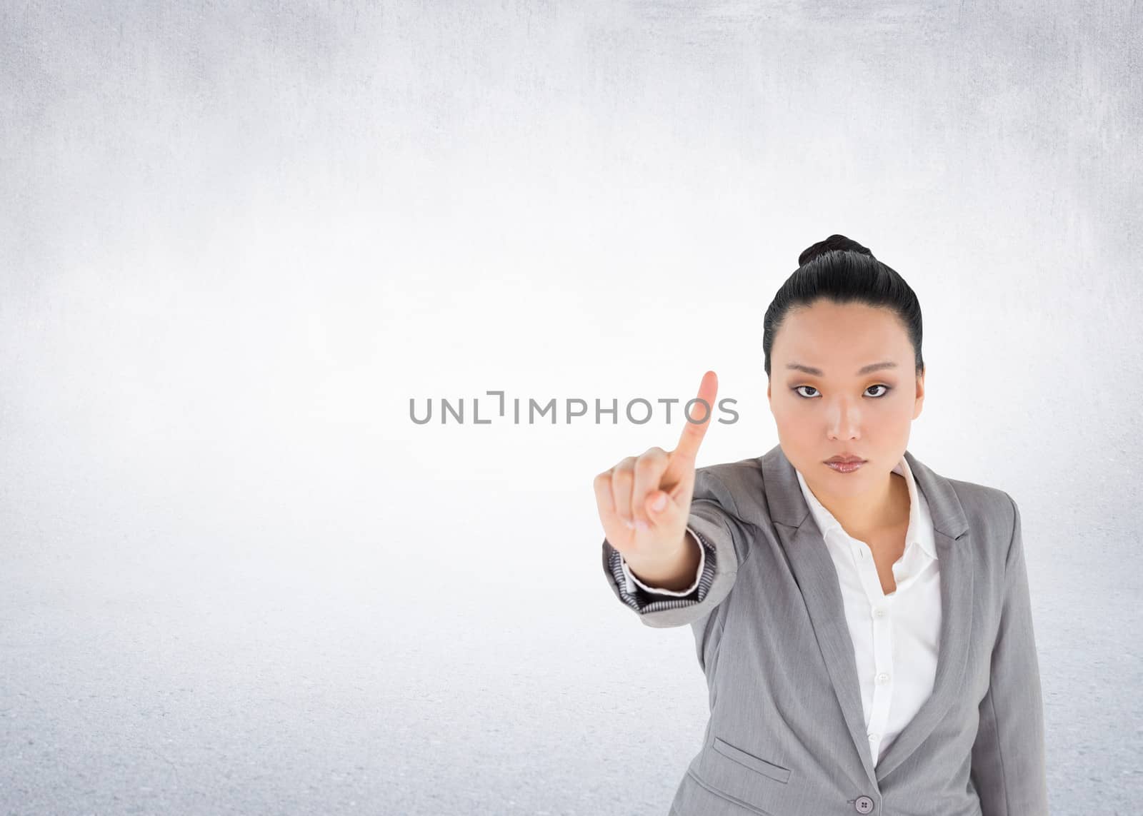 Composite image of unsmiling asian businesswoman pointing