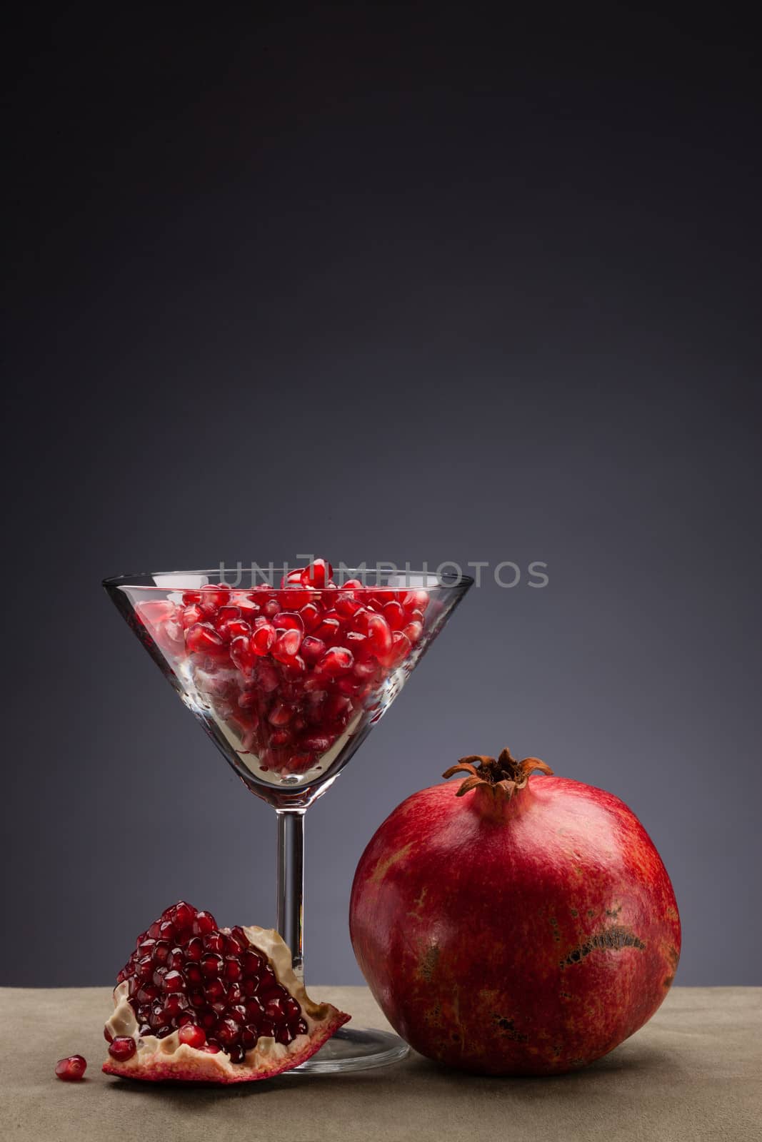 fresh and ripe pomegranate with glass full of seed