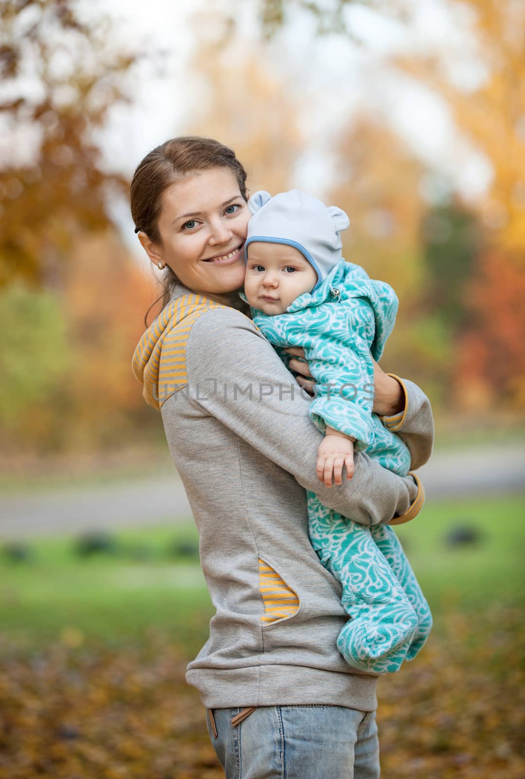 Portrait of young woman and her baby son in autumn park