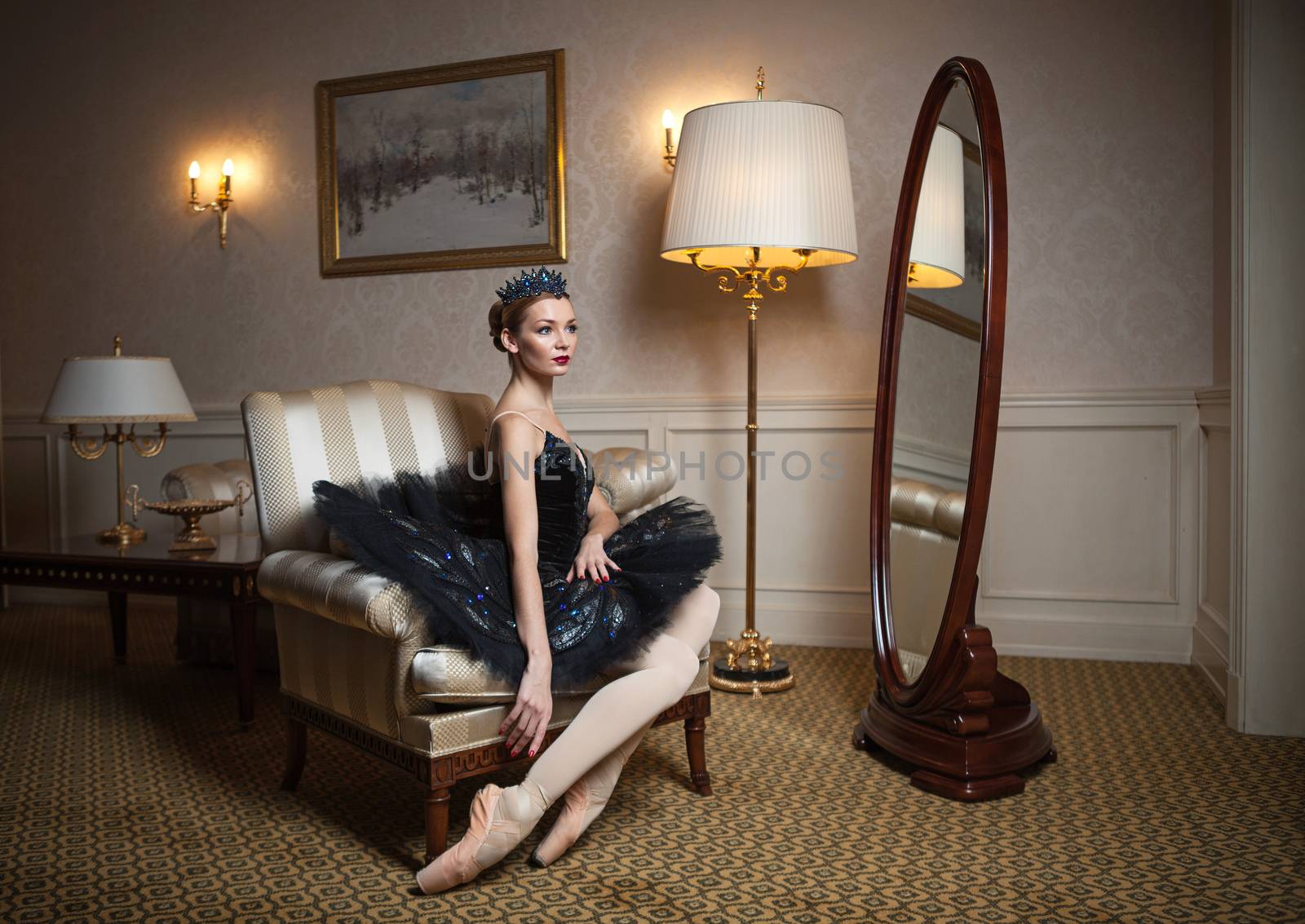 Ballerina in black tutu sitting in armchair by photobac