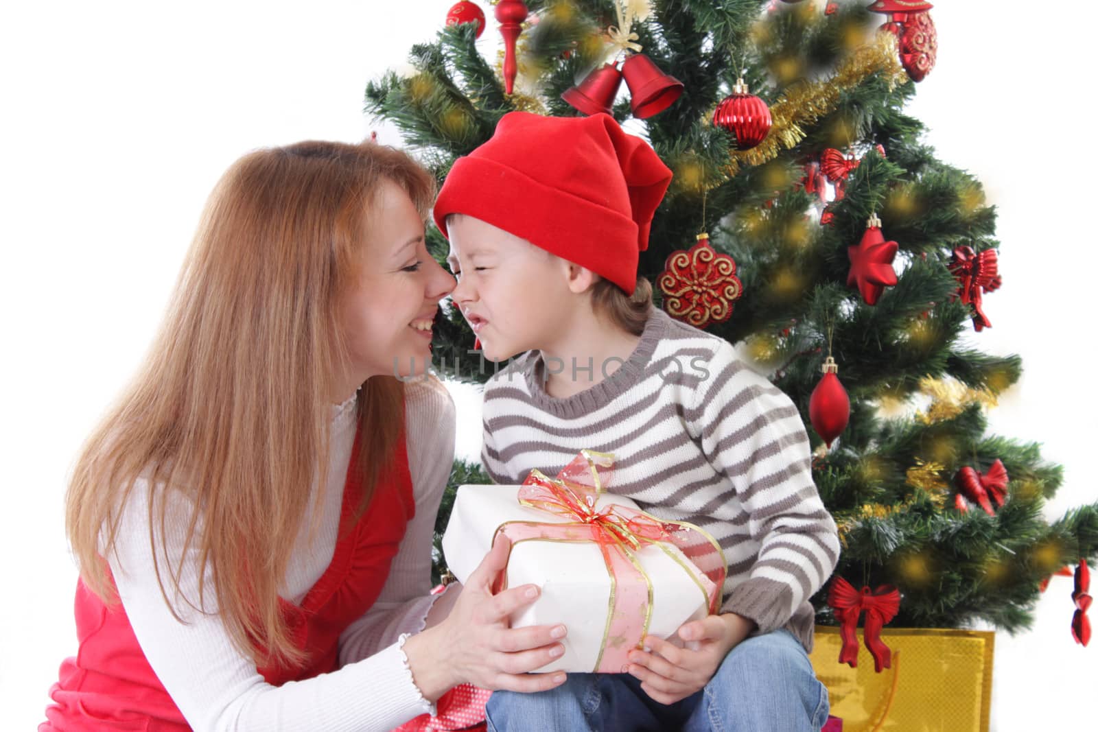 Happy mother and son having fun under Christmas tree isolated on white
