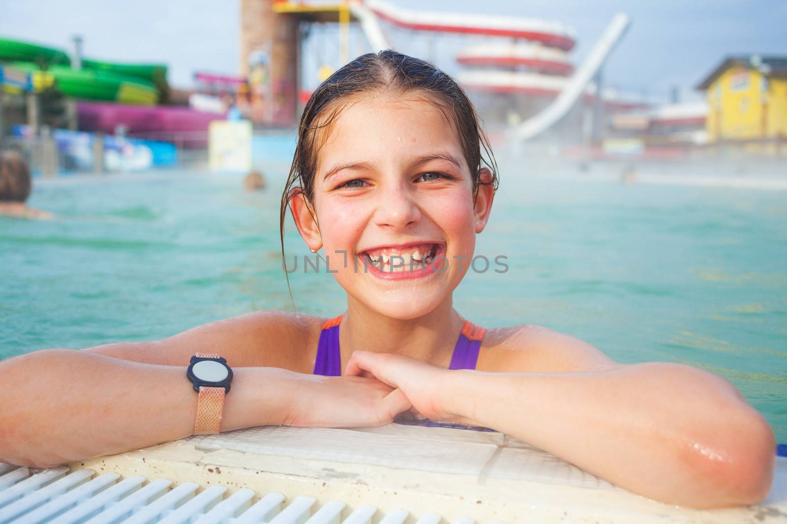 Activities on the pool. Cute girl swimming and playing in water in thermal hot pool