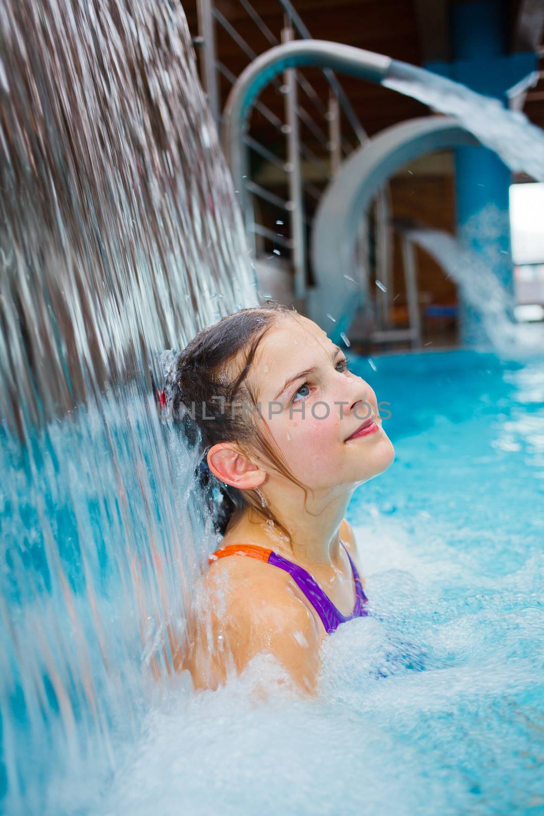 Activities on the pool. Cute girl swimming and playing in water in thermal hot pool