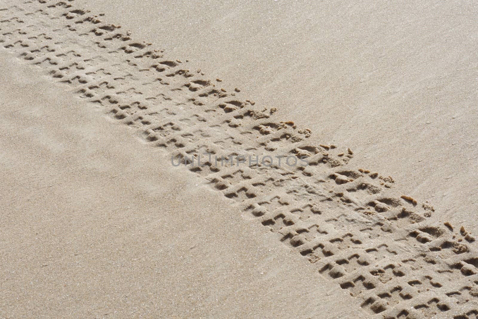 Diagonal track of quad bike on sand