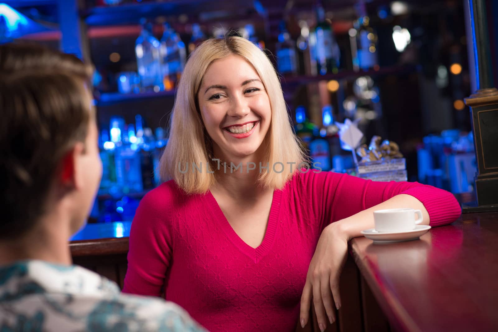 portrait of a nice woman at the bar, talking with a man at the bar date