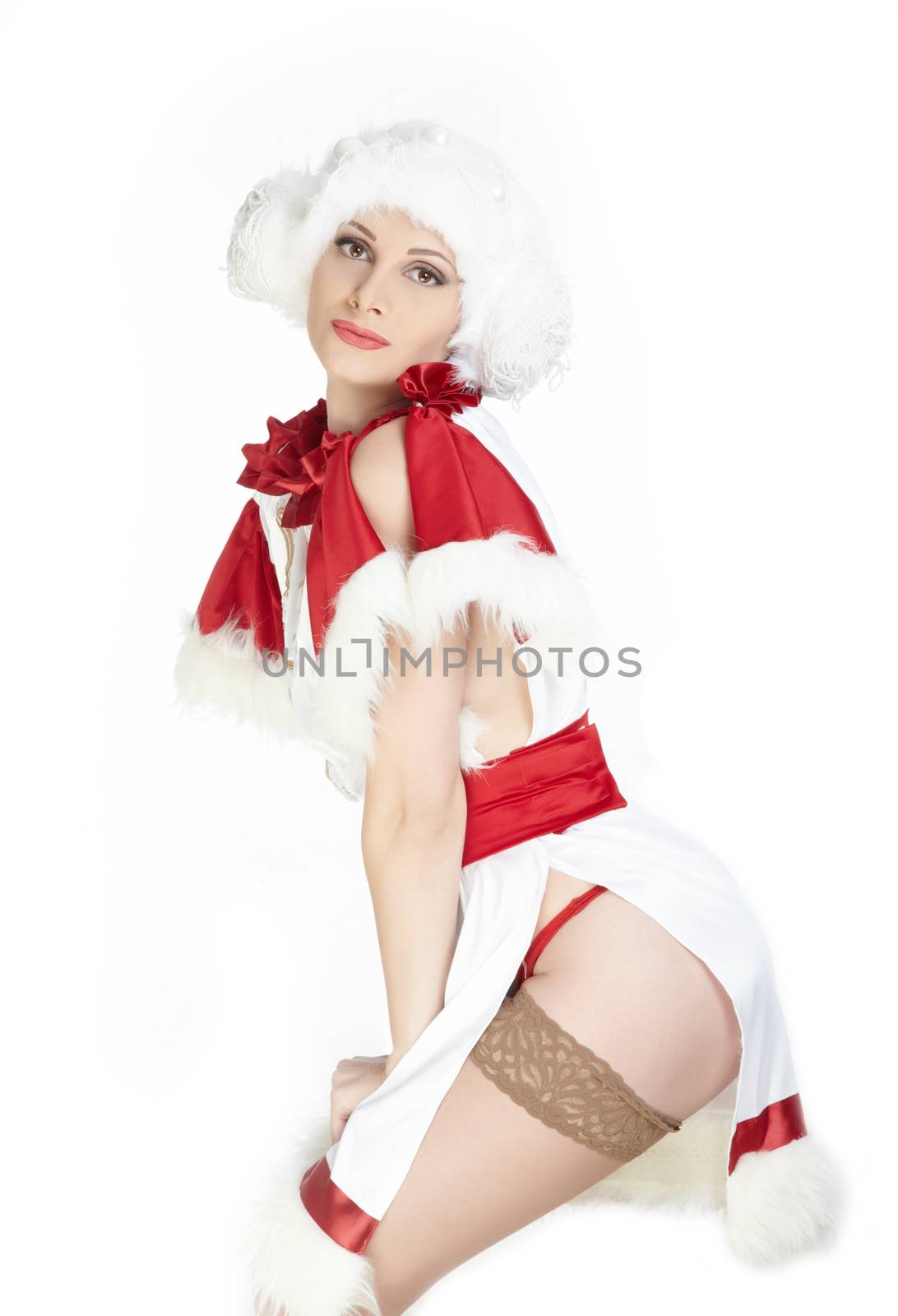 Sexy lady in the warm furry Christmas dress and cap on a white background