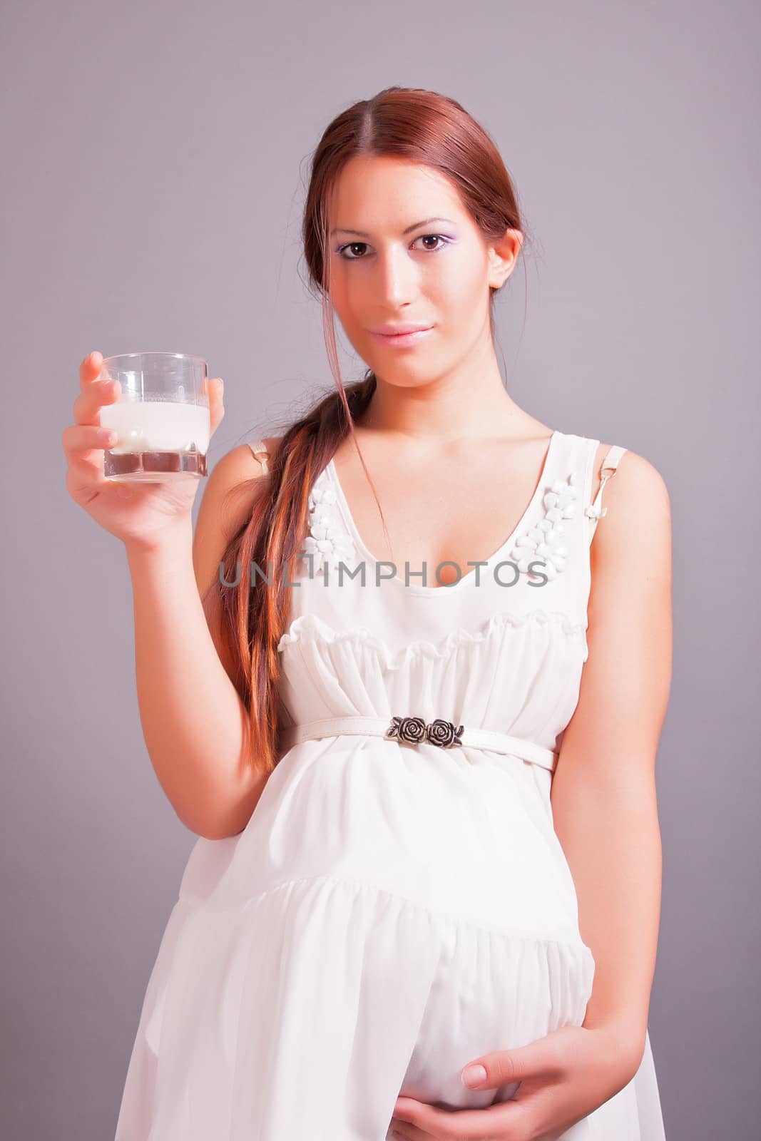 portrait of pregnant woman holding glass of milk