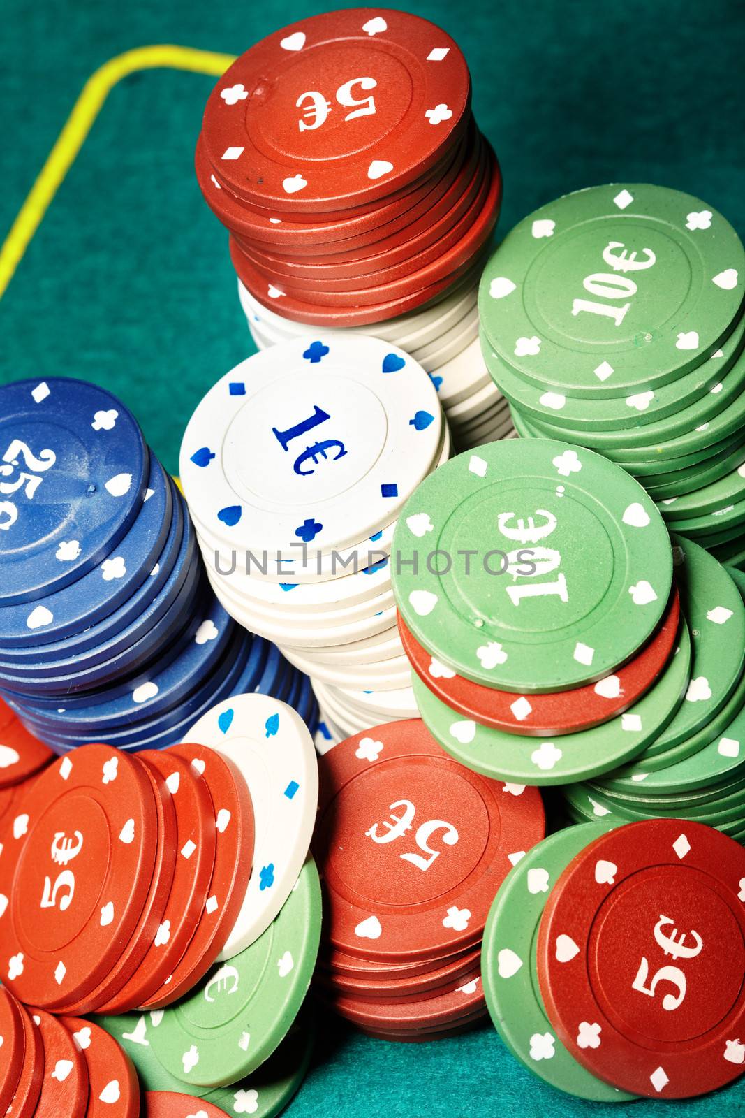 Stack of casino chips on a green casino table. Close-up photo