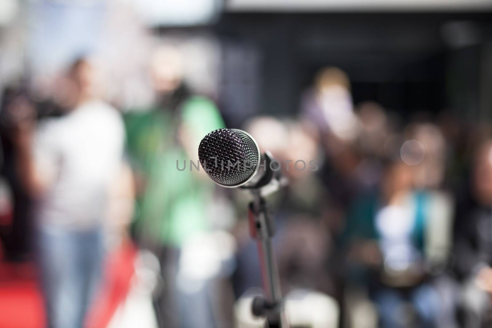 Microphone in focus against blurred audience