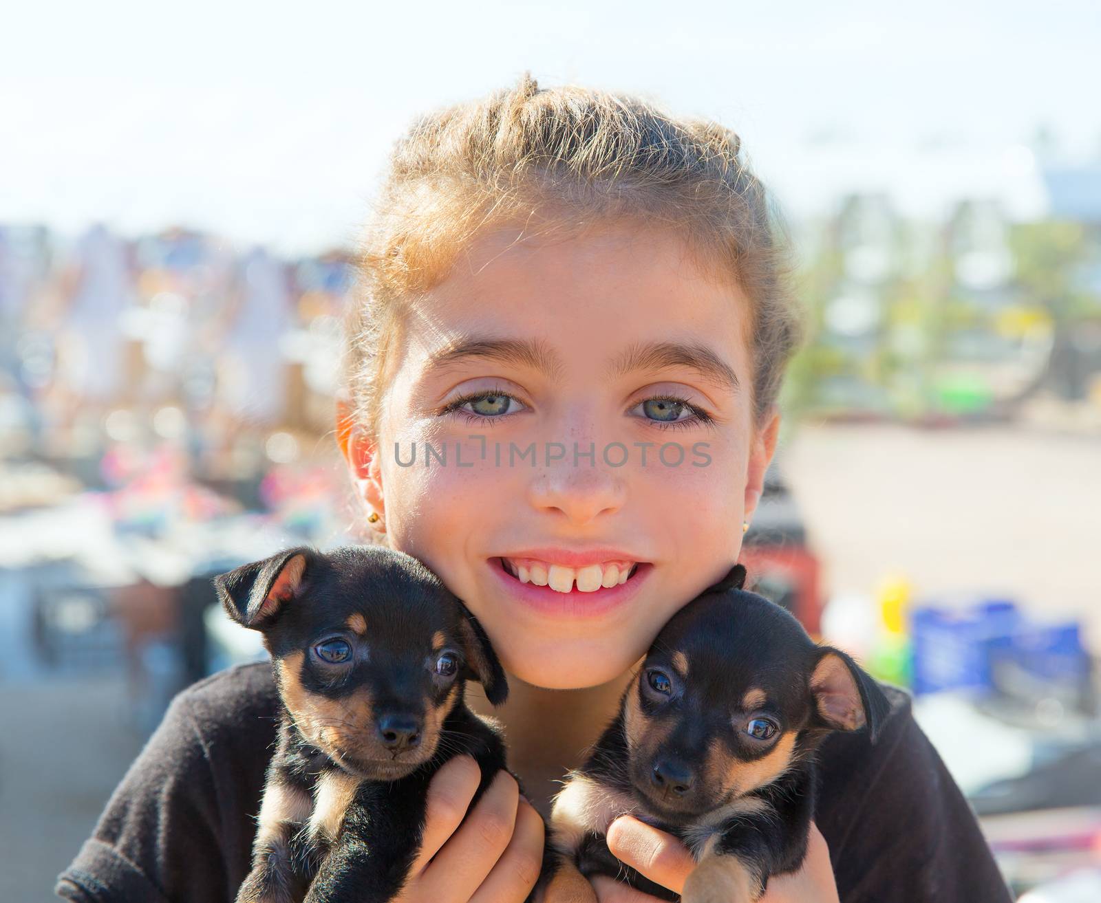 kid girl playing with puppy dogs smiling with blue eyes