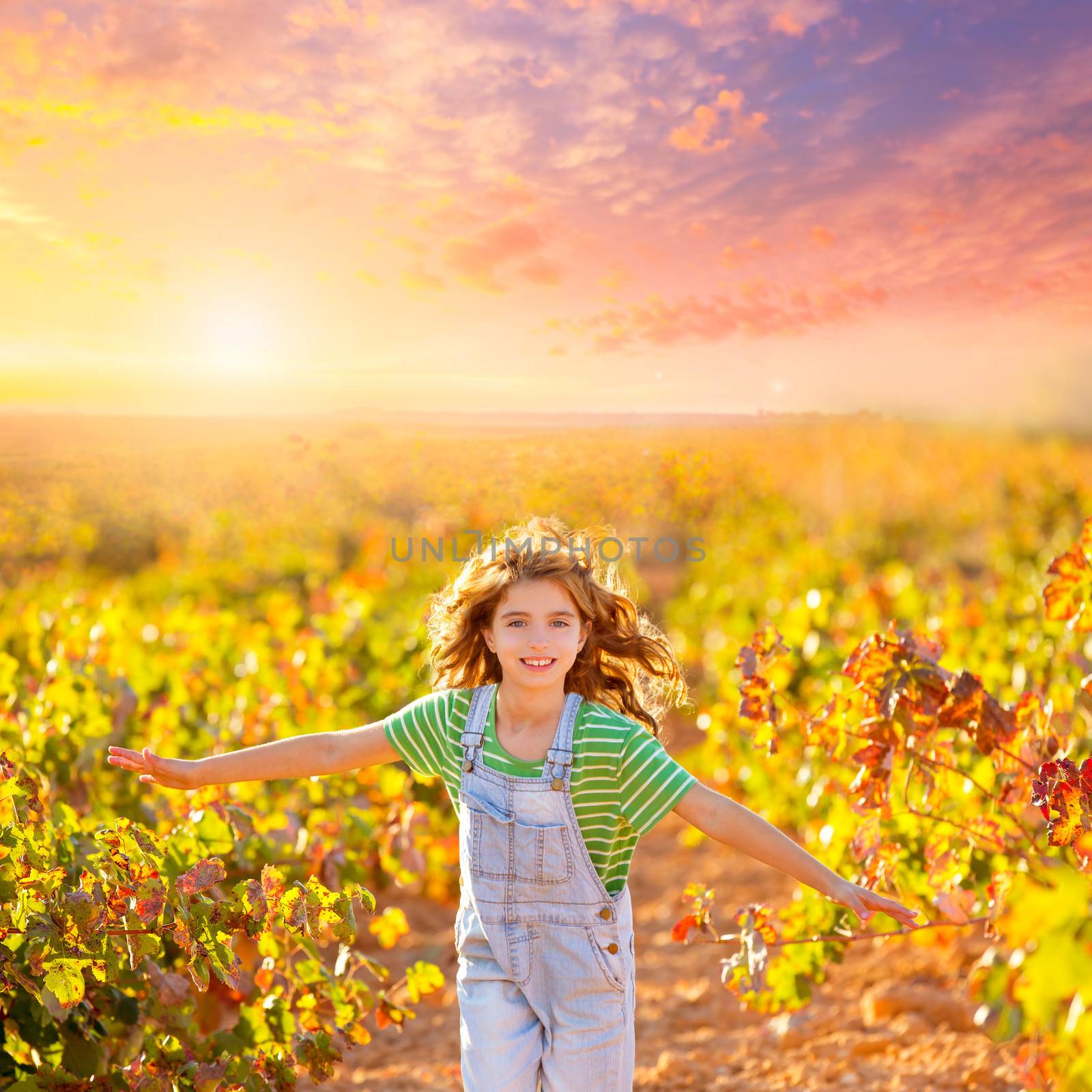 kid farmer girl running in vineyard field in autumn red leaves